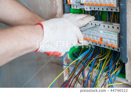 A electrician is installing the fuses. 44746522