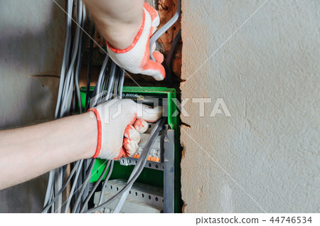 An electrician is installing electric wires. 44746534