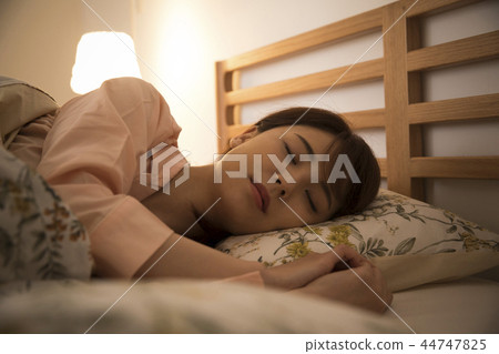 A young woman sleeping in bed A young woman sleeping in bed 44747825