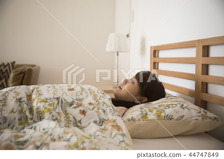 一個睡在床上的年輕女人 44747849