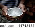 The poor old man's hands hold an empty bowl.  44748482