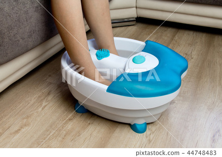 Feet in a vibrating foot massager. massage bath 44748483