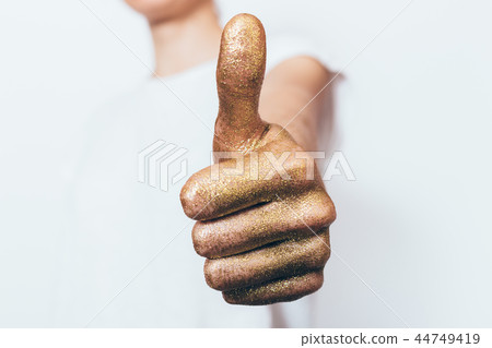 Female hand painted in golden showing thumb up Female hand painted in golden showing thumb up 44749419