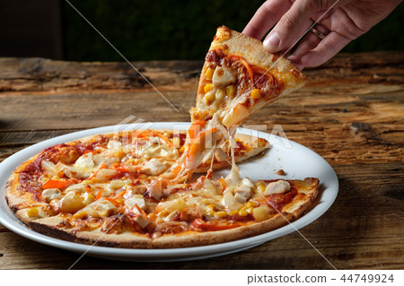Men's hand is taking piece of pizza 44749924