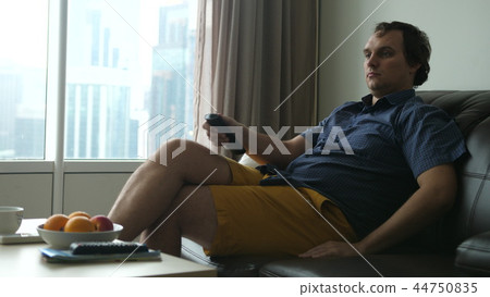 Handsome man watching a football match in his living room. 44750835