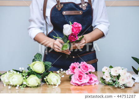 Arranging artificial flowers vest decoration at home, Young woma Arranging artificial flowers vest decoration at home, Young woma 44751287