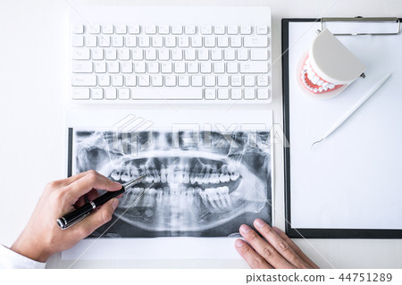 Male doctor or dentist working with patient tooth x-ray film, mo Male doctor or dentist working with patient tooth x-ray film, mo 44751289