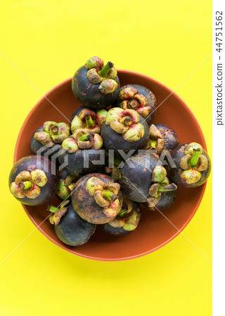 Mangostin tropical fruits in plate on yellow Mangostin tropical fruits in plate on yellow 44751562