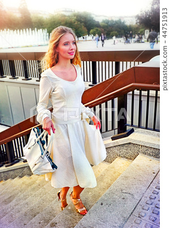 Fashion woman in autumn spring dress on city street. Fashion woman in autumn spring dress on city street. 44751913