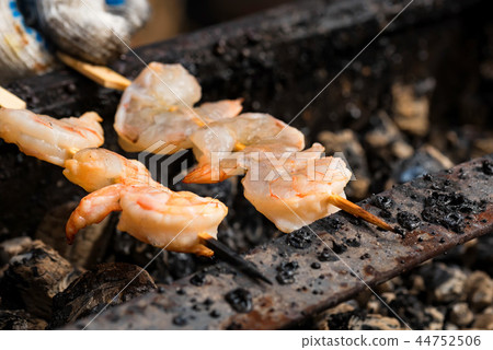 Grilled fried prawns on skewers on metal grid 44752506