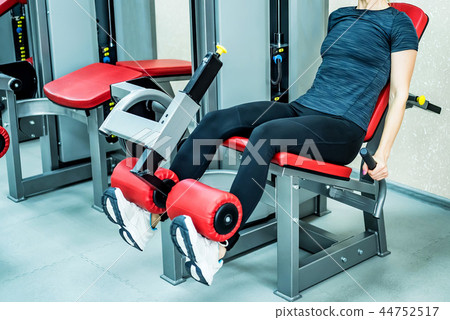Young woman does leg exercises in gym 44752517