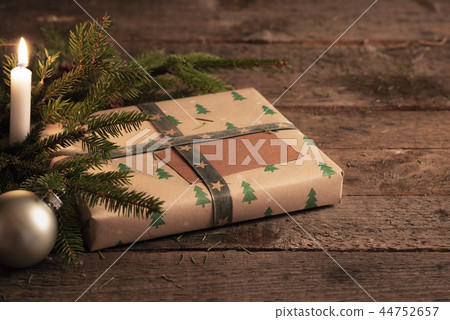 Christmas gift on rustic table at candlelight Christmas gift on rustic table at candlelight 44752657