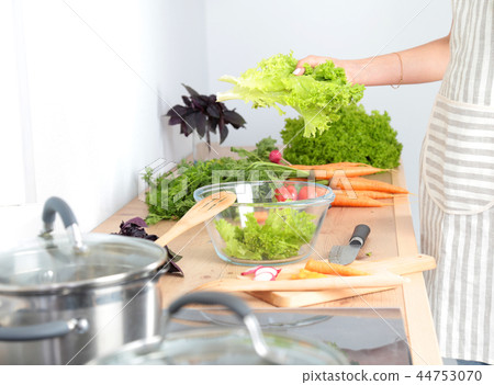 Fresh vegetables on the cutting board, salad in a glass dish. Concept of cooking 44753070