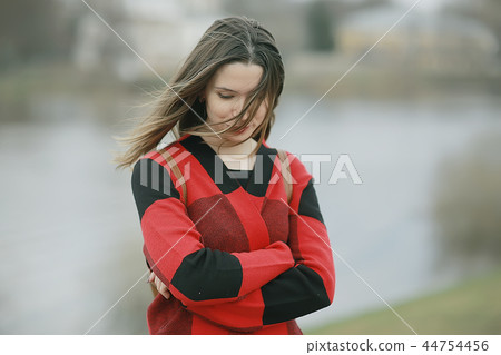 autumn sad girl outdoor / autumn weather, portrait of a young adult girl in a coat in a cage, Scottish style autumn sad girl outdoor / autumn weather, portrait of a young adult girl in a coat in a cage, Scottish style 44754456