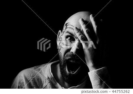 tattoo on the face, male portrait in the form of an assassin, cosplay, tattooed brutal man, guy with a tattooed face 44755262