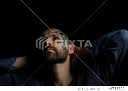 tattoo on the face, male portrait in the form of an assassin, cosplay, tattooed brutal man, guy with a tattooed face 44755331