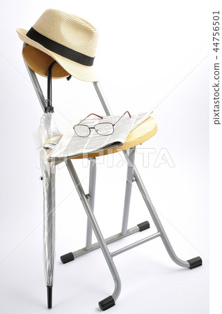 Newspaper, glasses and hat on a chair 44756501