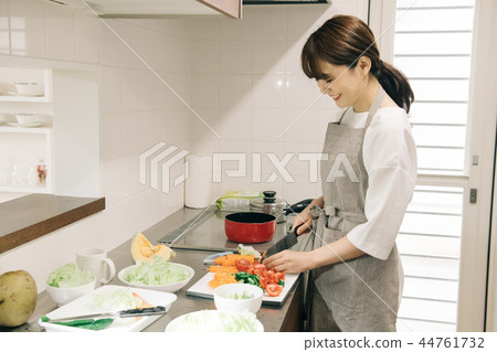 切日本食物的年輕主婦在廚房裡 切日本食物的年輕主婦在廚房裡 44761732