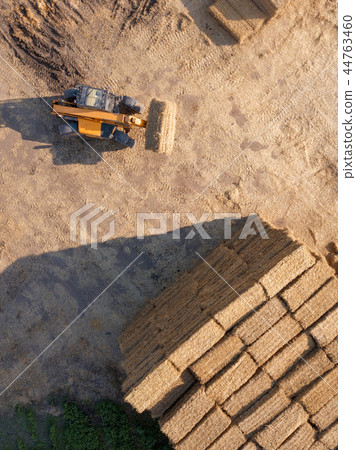 Aerial view from drone agricultural machine collecting bales of hay on a field. Farm industry. Top Aerial view from drone agricultural machine collecting bales of hay on a field. Farm industry. Top 44763460