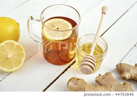 delicious hot tea with lemon on an old wooden table with ginger and honey 44763646