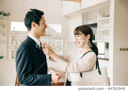 Wife repairing husband's tie young coworkers couple dinks Wife repairing husband's tie young coworkers couple dinks 44763948