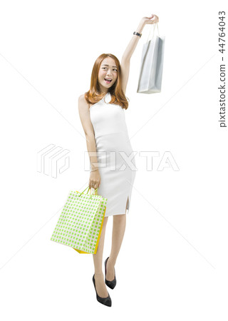 Woman in white dress holding shopping bags Woman in white dress holding shopping bags 44764043