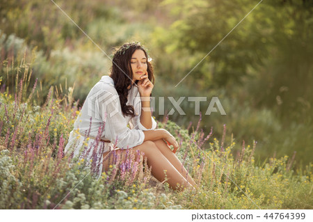 Beautiful carefree woman in fields being happy outdoors Beautiful carefree woman in fields being happy outdoors 44764399