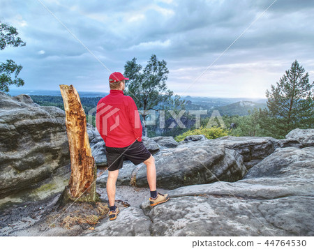 Adult hiker in red shirt and dark running pants Adult hiker in red shirt and dark running pants 44764530