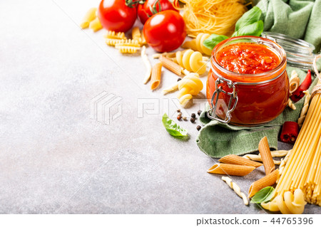Glass jar with homemade classic spicy tomato pasta or pizza sauce. Glass jar with homemade classic spicy tomato pasta or pizza sauce. 44765396