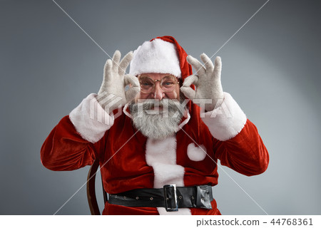 Cheerful Santa Claus sitting on chair and doing OK gesture Cheerful Santa Claus sitting on chair and doing OK gesture 44768361