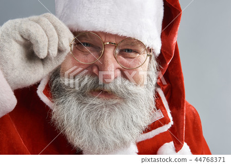 Joyful Santa Claus with beard touching eyeglasses 44768371