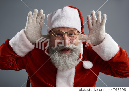 Cheerful Santa Claus in glasses making funny face Cheerful Santa Claus in glasses making funny face 44768398