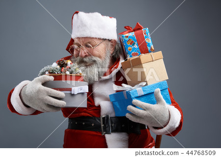 Santa Claus holding gifts in colorful boxes with ribbons 44768509