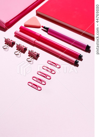 Pink paper clips, pink notebook and pink pencil case on a pink background. Pink paper clips, pink notebook and pink pencil case on a pink background. 44769880