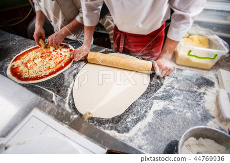Preparation of dough for pizza. Cooking pizza in the cafe. 44769936