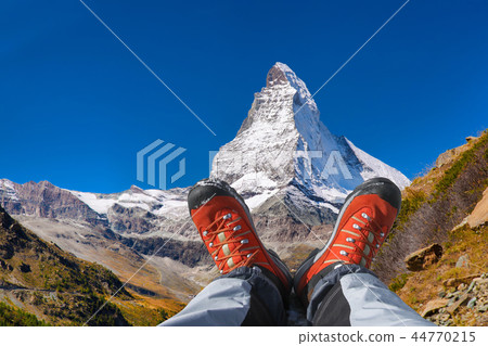 Matterhorn peak with hiking boots in Swiss Alps. 44770215