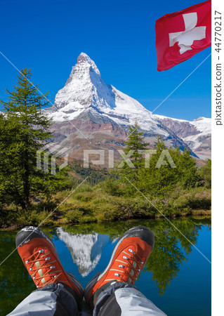 Matterhorn peak with hiking boots in Swiss Alps. 44770217