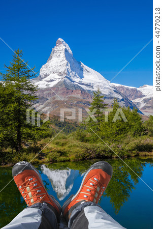 Matterhorn peak with hiking boots in Swiss Alps. 44770218