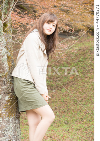 A woman in autumn leaves A woman in autumn leaves 44770271