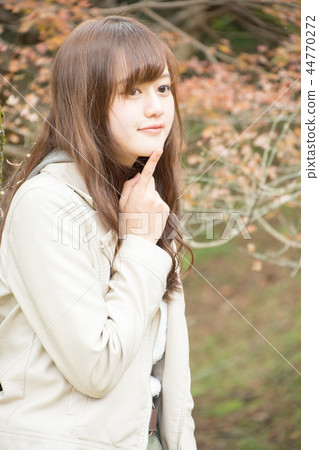 A woman in autumn leaves A woman in autumn leaves 44770272