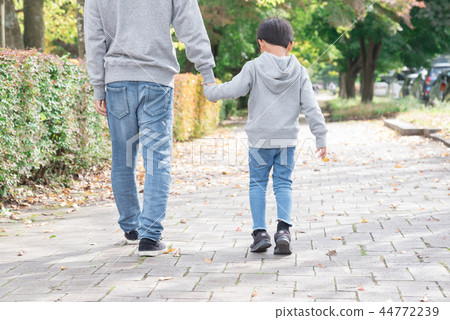 Parent and child holding hands and walking Parent and child holding hands and walking 44772239
