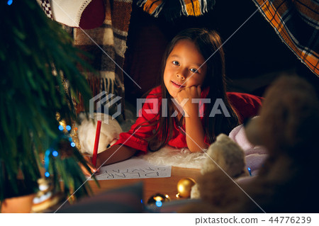 Merry Christmas and Happy Holidays. Cute little child girl writes the letter to Santa Claus near Merry Christmas and Happy Holidays. Cute little child girl writes the letter to Santa Claus near 44776239