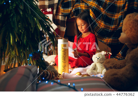 Merry Christmas and Happy Holidays. Cute little child girl writes the letter to Santa Claus near Merry Christmas and Happy Holidays. Cute little child girl writes the letter to Santa Claus near 44776362