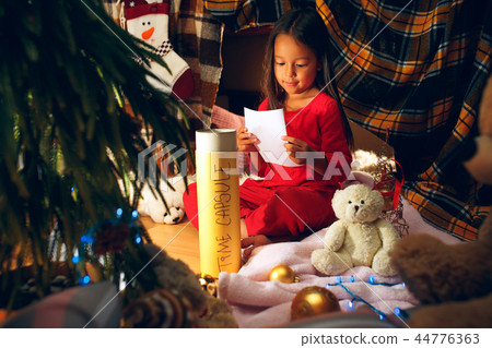 Merry Christmas and Happy Holidays. Cute little child girl writes the letter to Santa Claus near Merry Christmas and Happy Holidays. Cute little child girl writes the letter to Santa Claus near 44776363