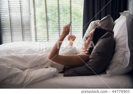 Happy attractive young European female smiling broadly while reading text message from her boyfriend 44778905