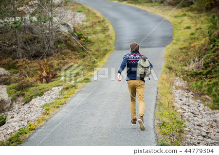 Traveler walking along the road.  44779304