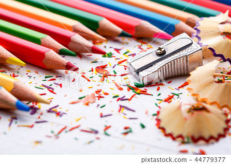 Pile of sharp coloured drawing pencils on table. 44779377