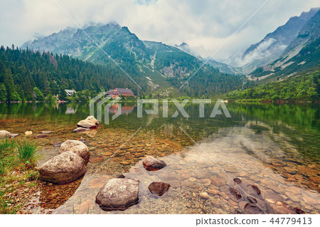 The lake is high in the mountains in the clouds. Hotel near the lake in the mountains. 44779413