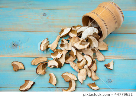 Dried mushrooms, on a blue wooden table 44779631