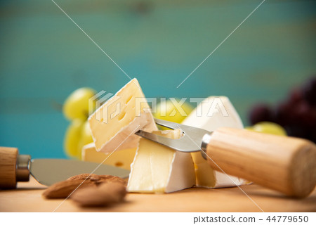 cheese camembert with raspberries and grapes on table 44779650